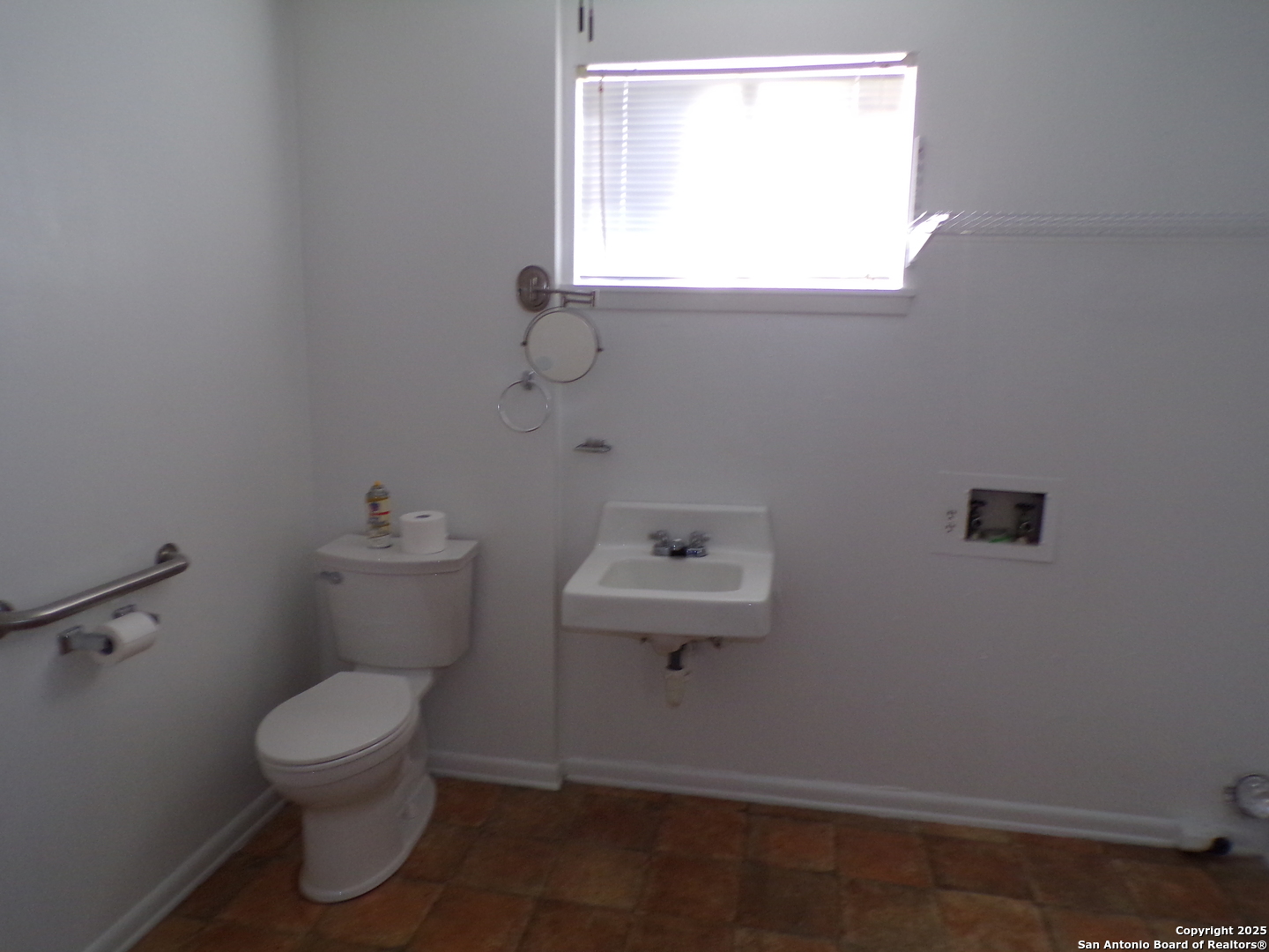 409 Bohme Street Uvalde, TX 78801 - Photo 7 of 9 a bathroom with a toilet a sink and a window