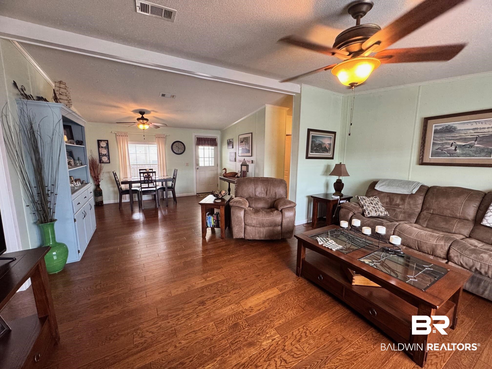 1165 Santa Anna Lane Lillian, AL 36549 - Photo 8 of 43 Living room featuring dark wood-style flooring, lofted ceiling, visible vents, a ceiling fan, and a textured ceiling