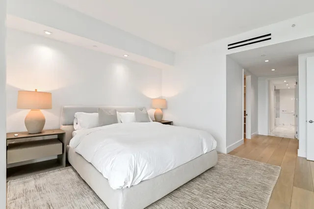 a bedroom with a bed and a potted plant