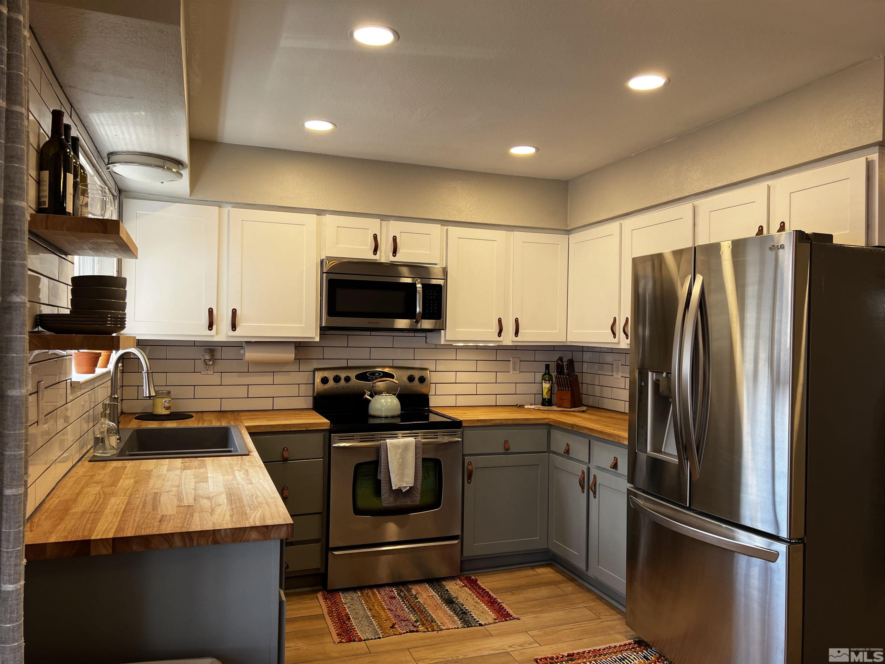 6412 Flower Street Reno, NV 89506 - Photo 13 of 38 a kitchen with stainless steel appliances granite countertop a refrigerator stove and microwave
