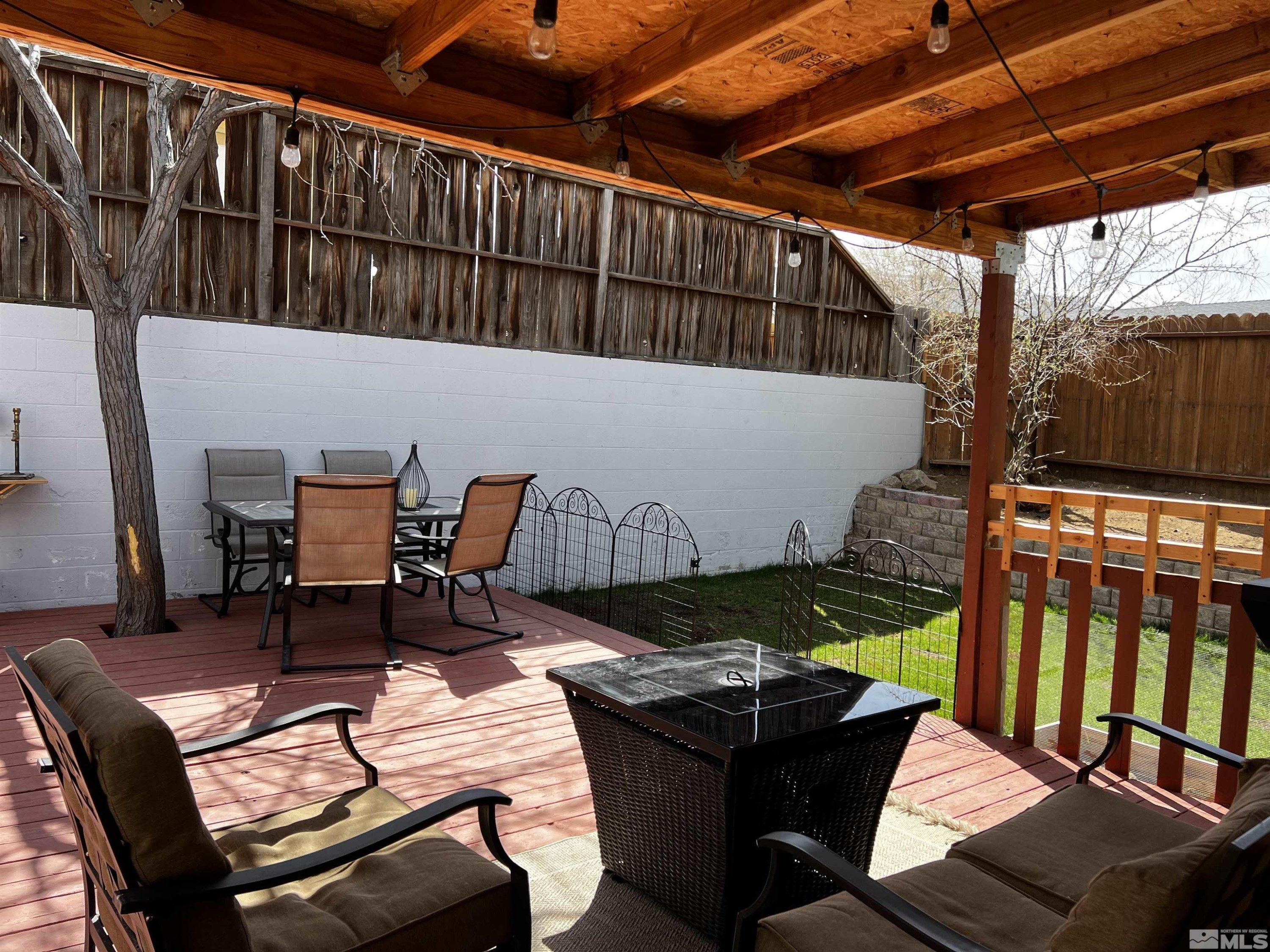 6412 Flower Street Reno, NV 89506 - Photo 27 of 38 a view of a patio with table and chairs with wooden floor