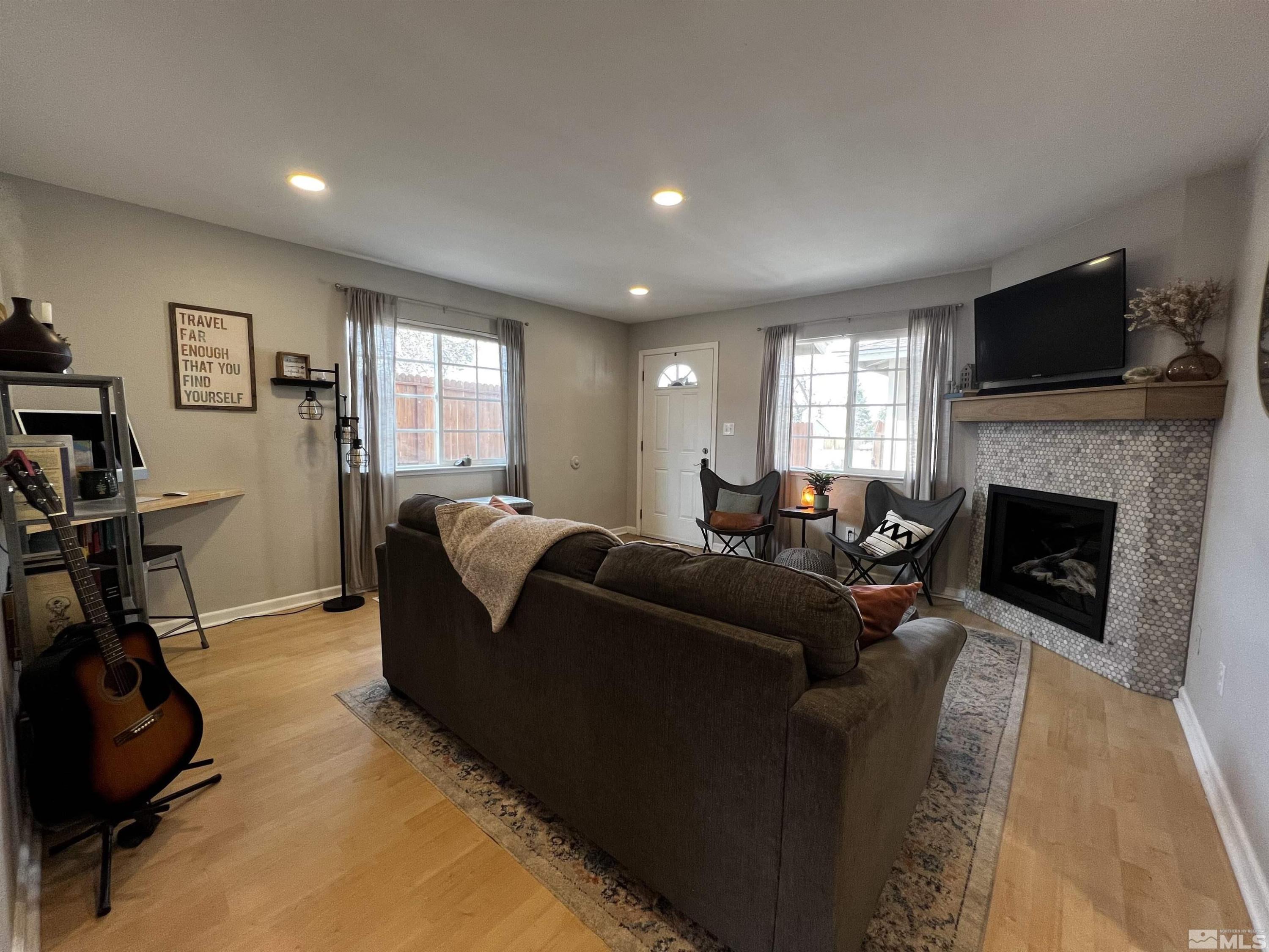 6412 Flower Street Reno, NV 89506 - Photo 8 of 38 a living room with furniture a flat screen tv and a fireplace