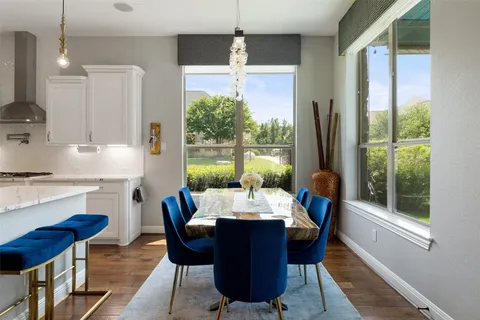 a dining room with furniture a chandelier and wooden floor