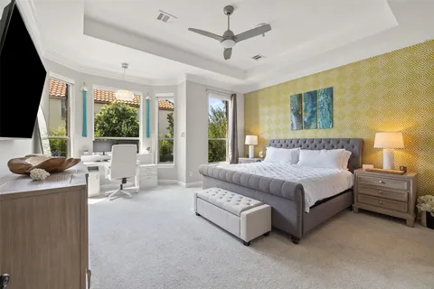 a bedroom with a large bed and a flat tv screen on dresser