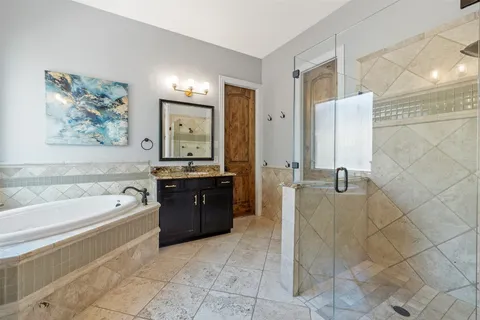 a spacious bathroom with a tub sink and mirror