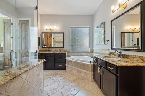 a large bathroom with a granite countertop sink a bathtub a mirror and shower