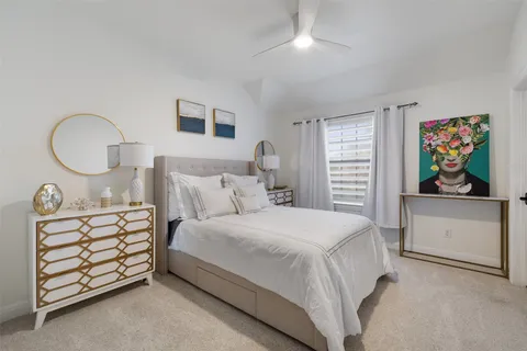a bedroom with a bed a dresser and painting on the wall