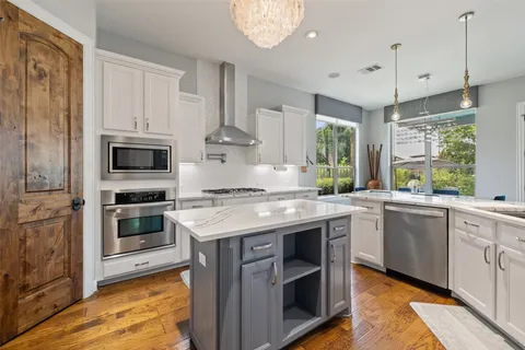 a kitchen with stainless steel appliances granite countertop a stove and a sink