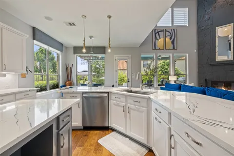 a kitchen with a sink a center island a stove and a window