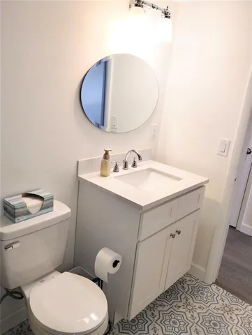 a bathroom with a toilet a sink and mirror