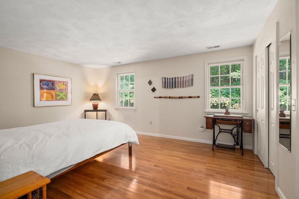 10 Apple Ridge Road, Unit 4 Maynard, MA 01754 - Photo 14 of 27 a bedroom with a bed and a table in it