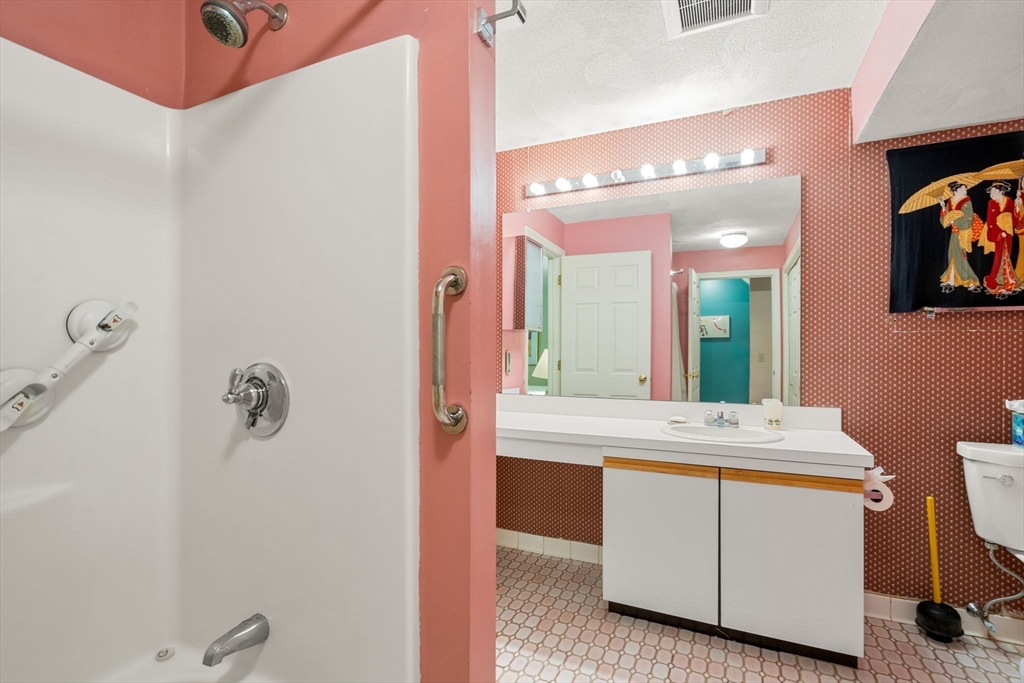 10 Apple Ridge Road, Unit 4 Maynard, MA 01754 - Photo 18 of 27 a bathroom with a sink a mirror and vanity