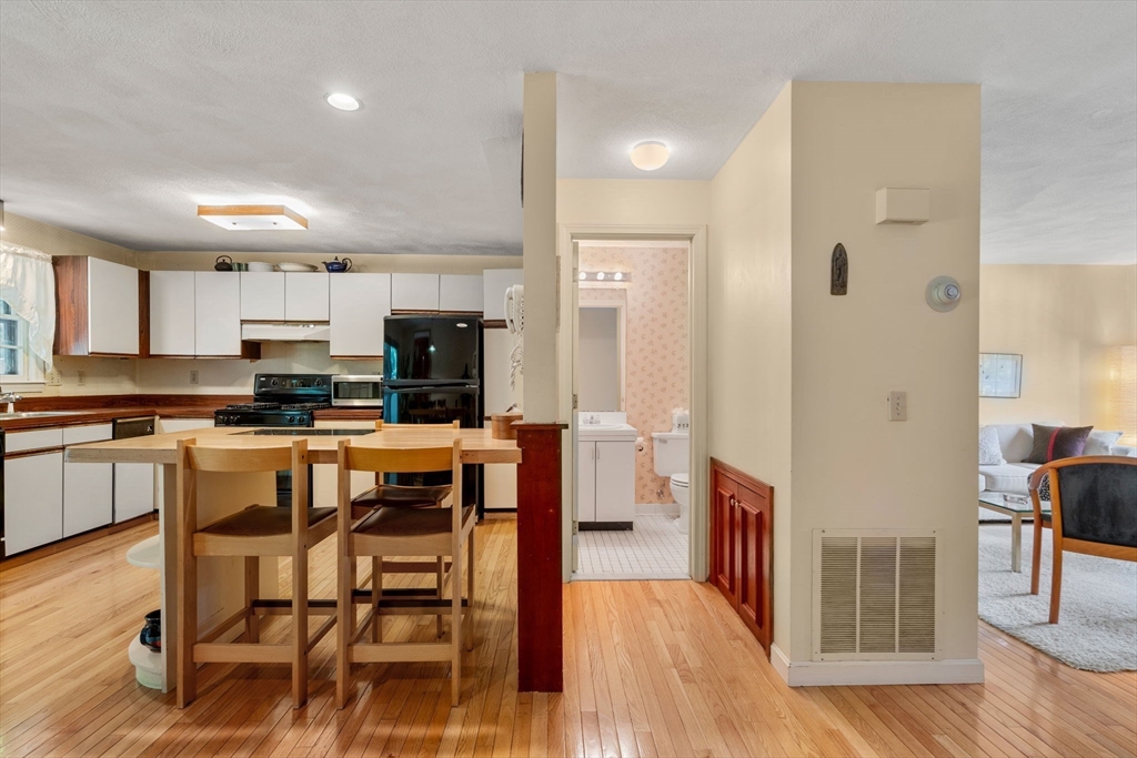 10 Apple Ridge Road, Unit 4 Maynard, MA 01754 - Photo 6 of 27 a open kitchen with stainless steel appliances granite countertop a stove top oven a sink dishwasher a dining table and chairs with wooden floor