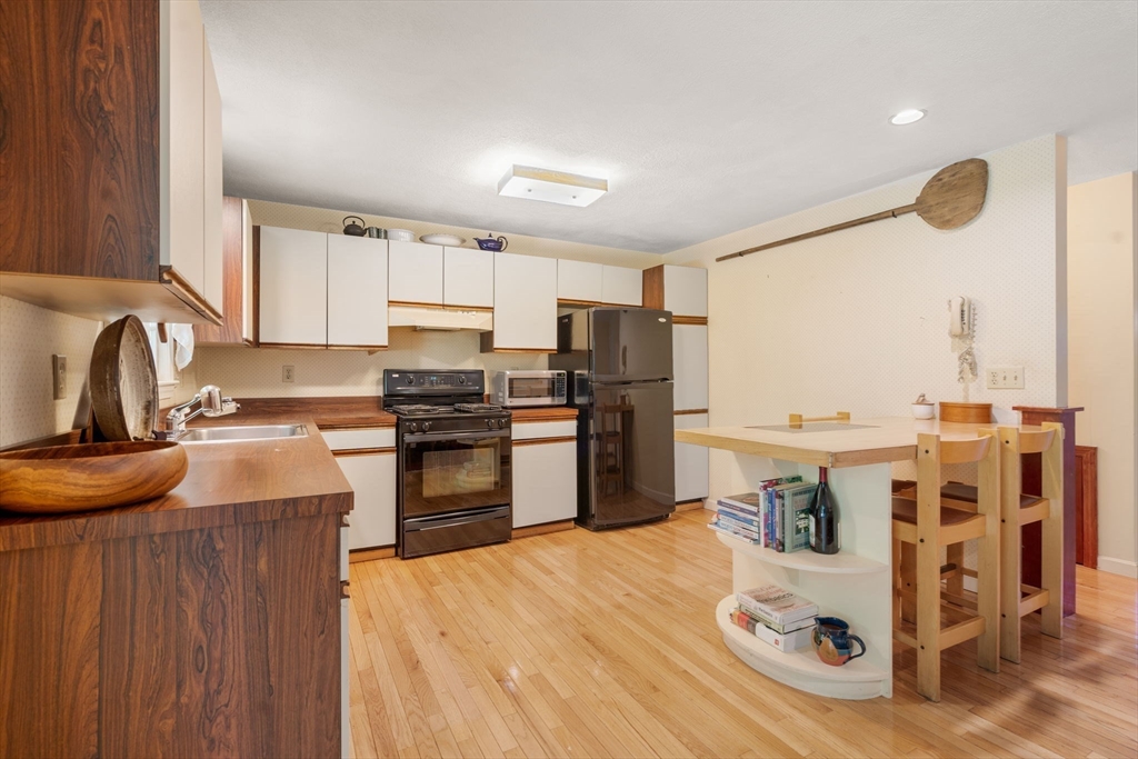 10 Apple Ridge Road, Unit 4 Maynard, MA 01754 - Photo 9 of 27 a kitchen with granite countertop a stove top oven sink and cabinets