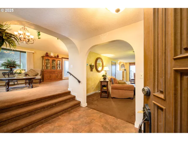 a view of living room filled with furniture and a chandelier