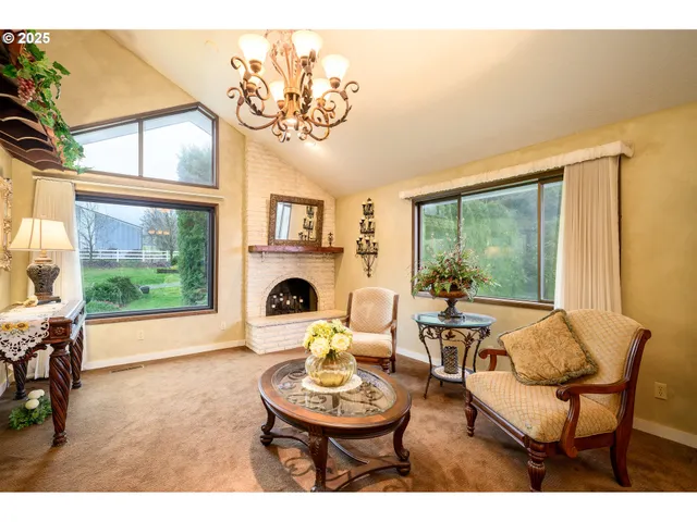 a living room with furniture a fireplace and a large window