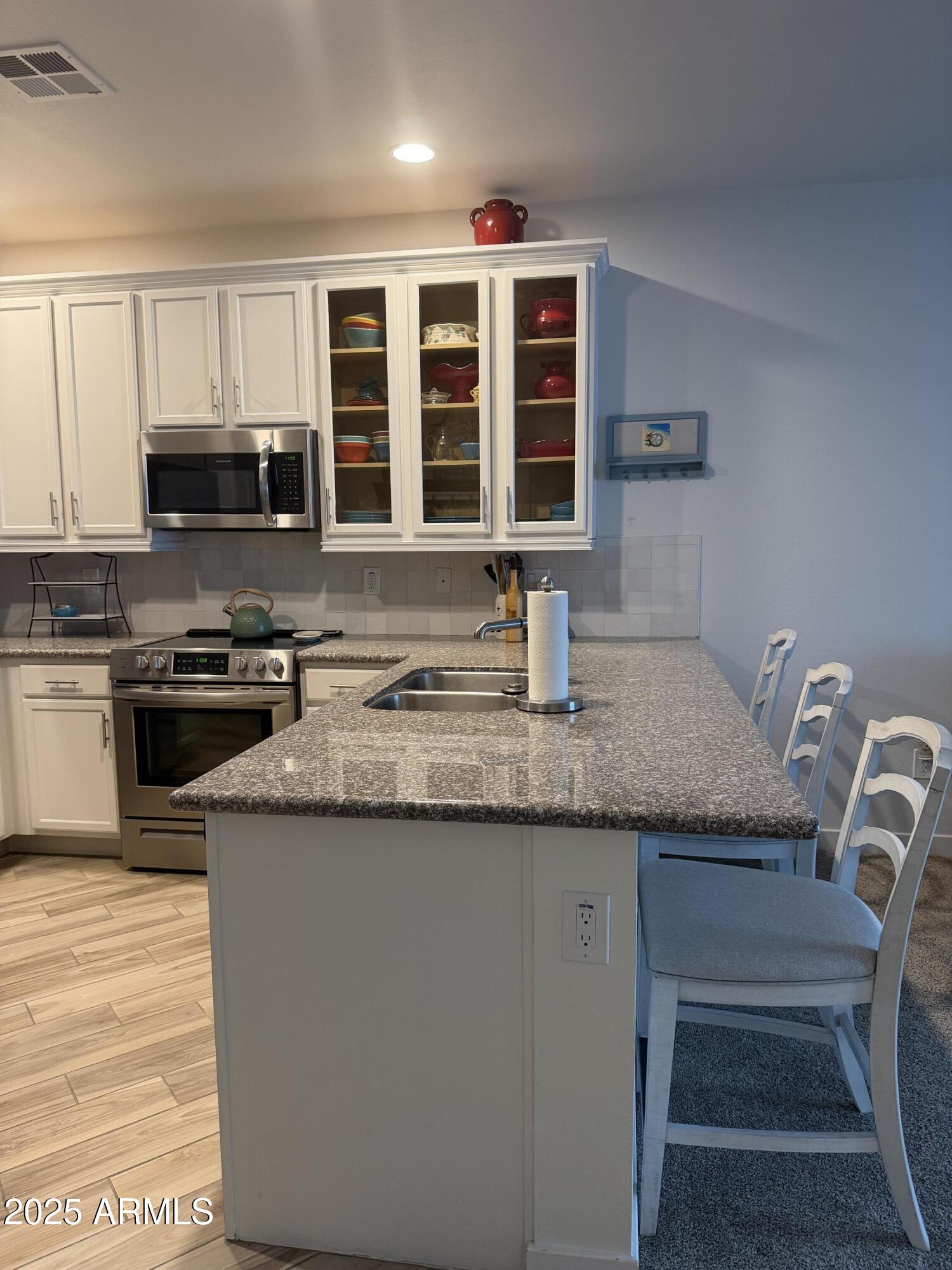 2511 West Queen Creek Road, Unit 223 Chandler, AZ 85248 - Photo 21 of 29 a kitchen with granite countertop a stove and a sink