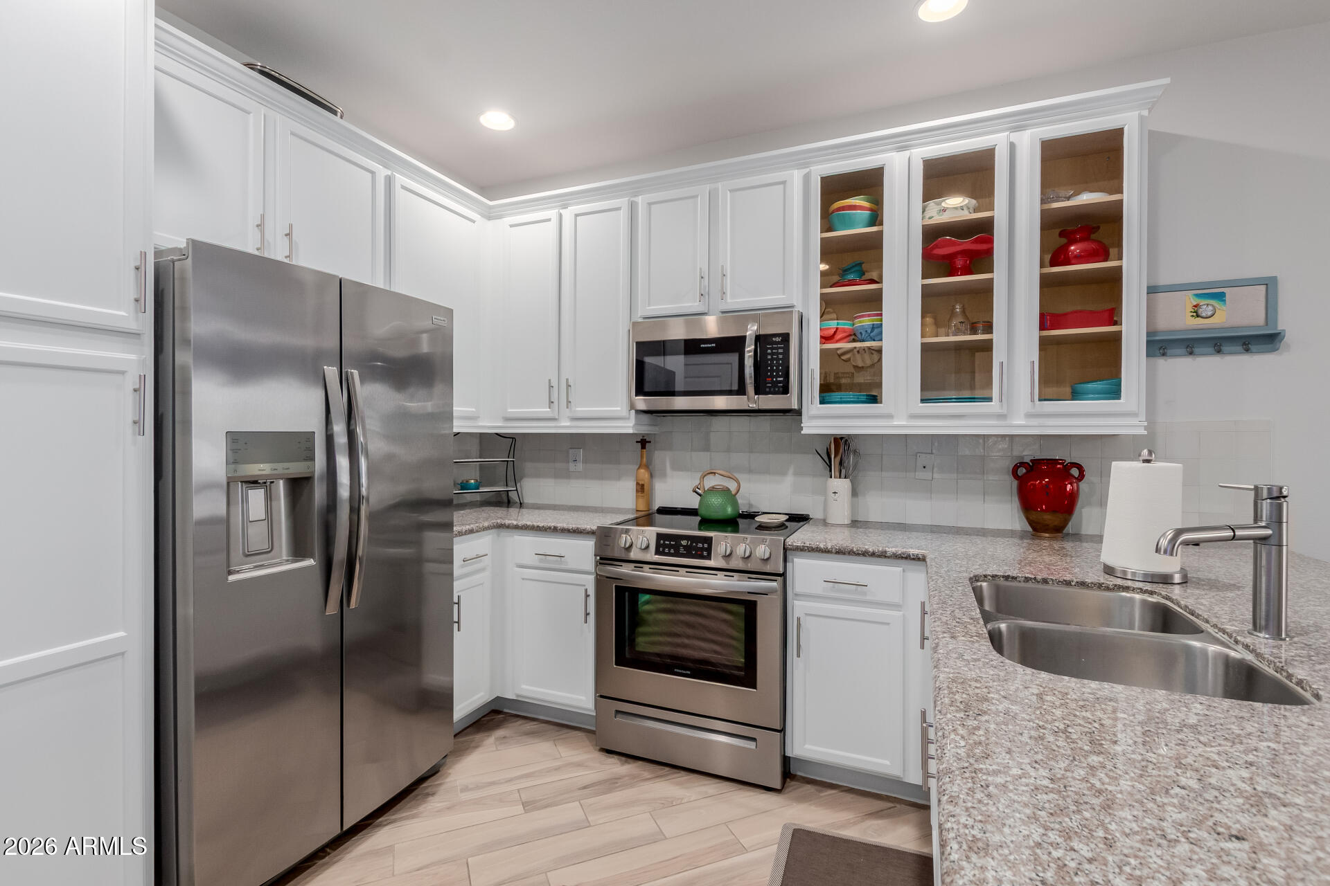 2511 West Queen Creek Road, Unit 223 Chandler, AZ 85248 - Photo 9 of 61 a kitchen with stainless steel appliances granite countertop a refrigerator a stove a sink and a microwave