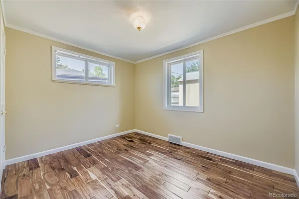 a view of empty room with wooden floor