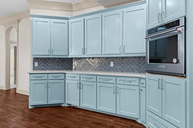 a kitchen with granite countertop white cabinets and stainless steel appliances
