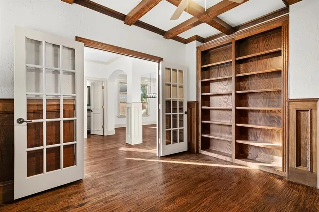 a view of empty room with wooden floor and shelves