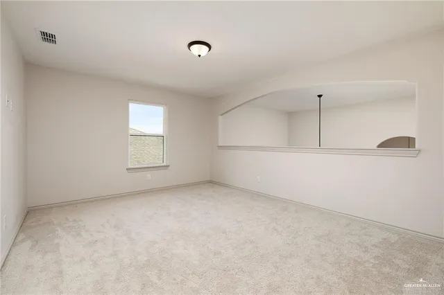 an empty room with cabinet and windows