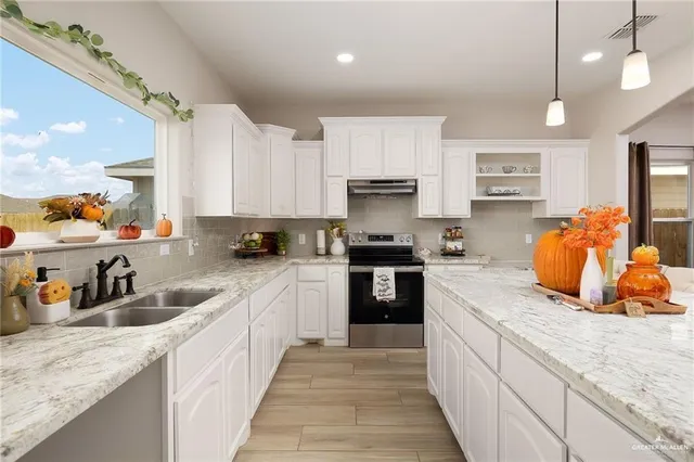 a kitchen with stainless steel appliances granite countertop a sink refrigerator and cabinets