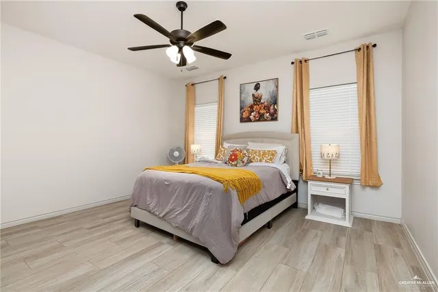 a bedroom with a large bed chandelier and a window