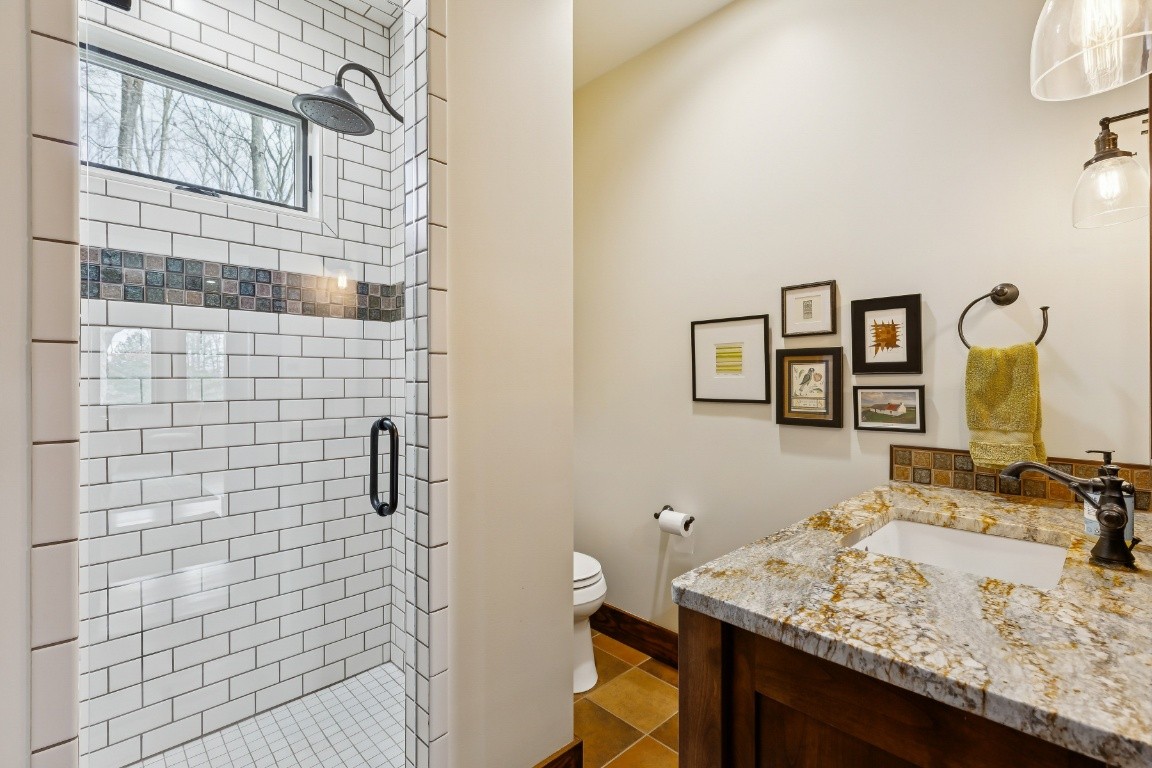 394 Myers Point Road Sewanee, TN 37375 - Photo 26 of 44 a bathroom with a granite countertop sink a toilet and shower