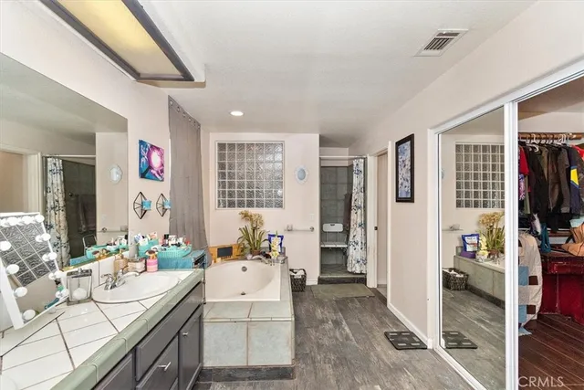 a living room with furniture a flat screen tv and a refrigerator