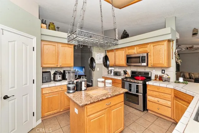 a kitchen with granite countertop a sink stainless steel appliances and cabinets