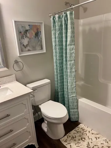 a white toilet sitting next to a bath tub and a shower