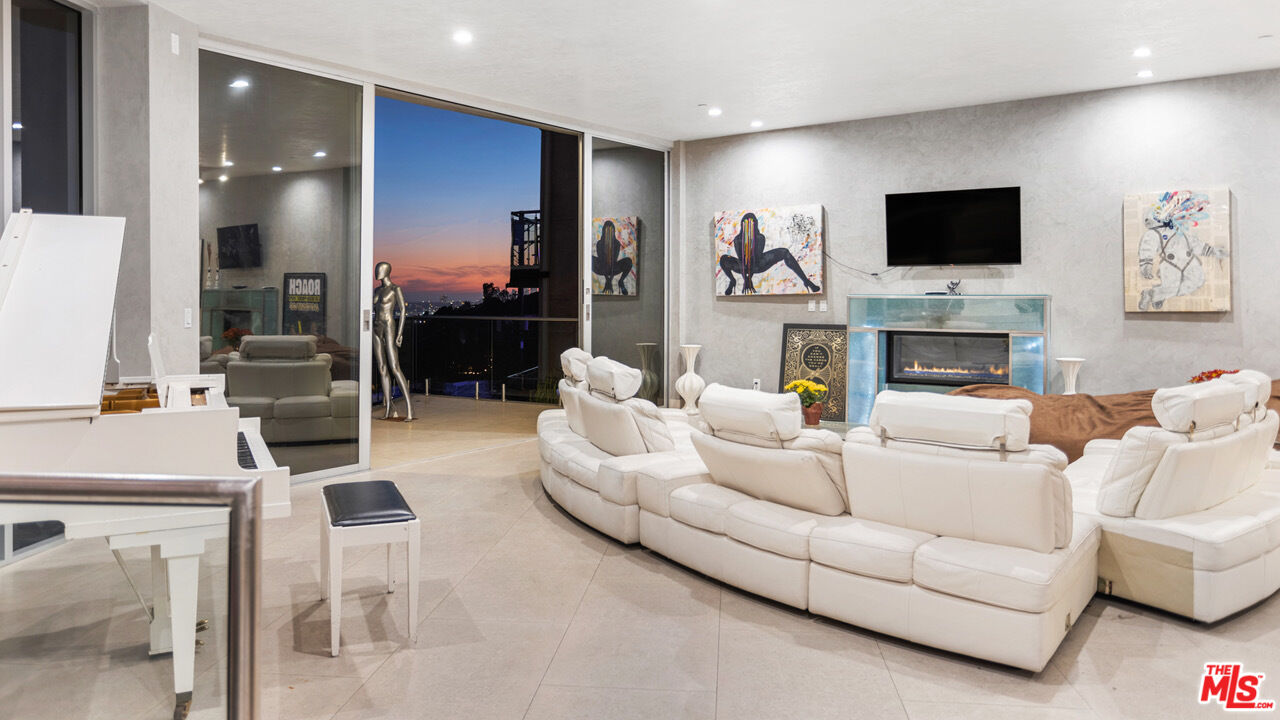 6425 Weidlake Drive Los Angeles, CA 90068 - Photo 15 of 37 a living room with furniture a flat screen tv and a fireplace