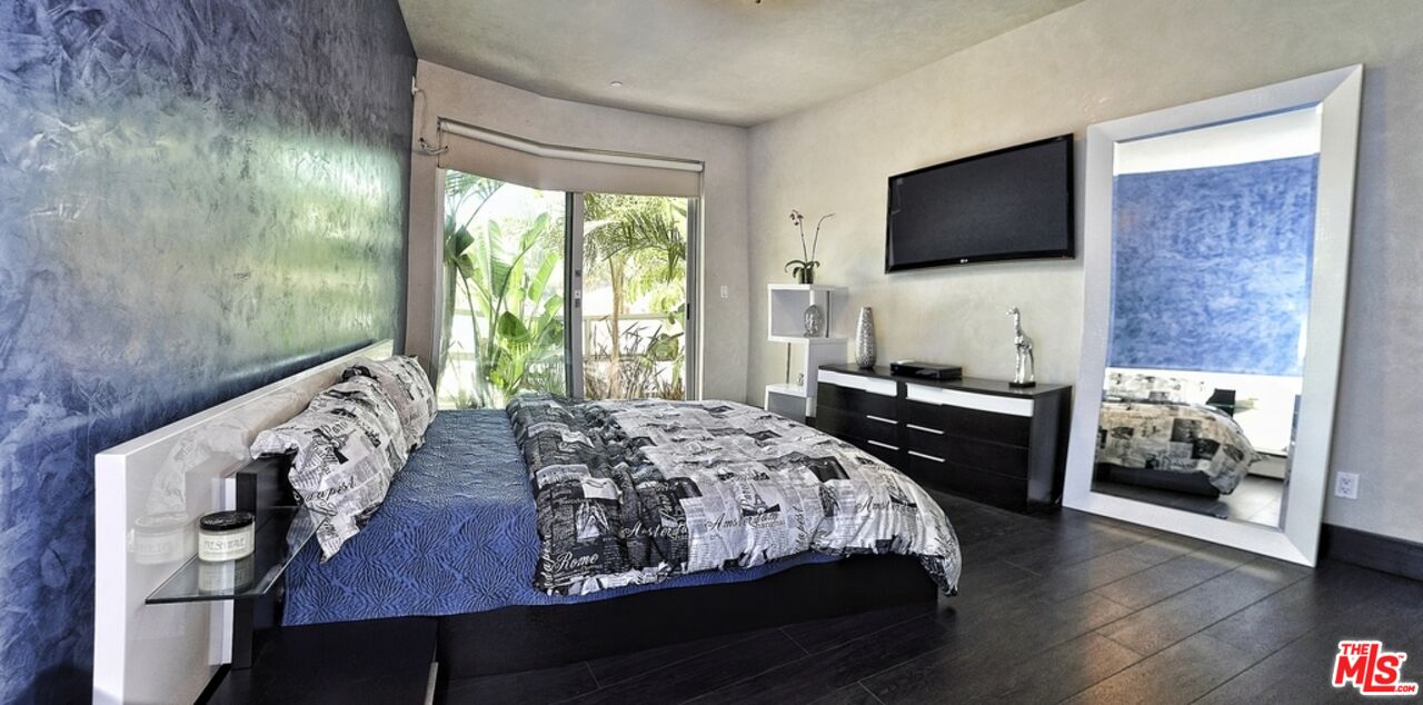 6425 Weidlake Drive Los Angeles, CA 90068 - Photo 27 of 37 a bedroom with a bed and a flat tv screen on the dresser