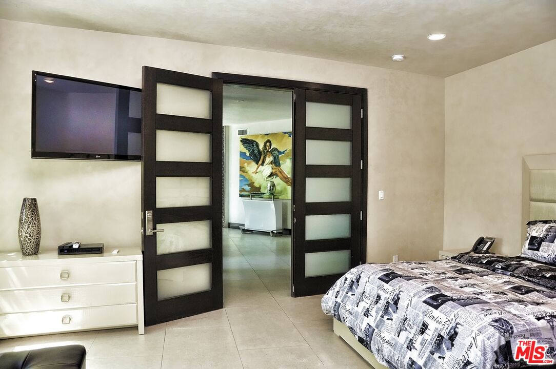 6425 Weidlake Drive Los Angeles, CA 90068 - Photo 30 of 37 a bedroom with a bed and a flat screen tv