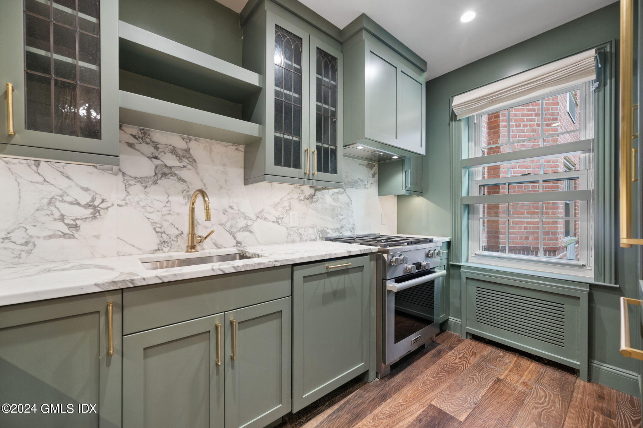 20 Church Street, Unit B11 Greenwich, CT 06830 - Photo 15 of 23 a kitchen with stainless steel appliances granite countertop a sink a stove and wooden cabinets
