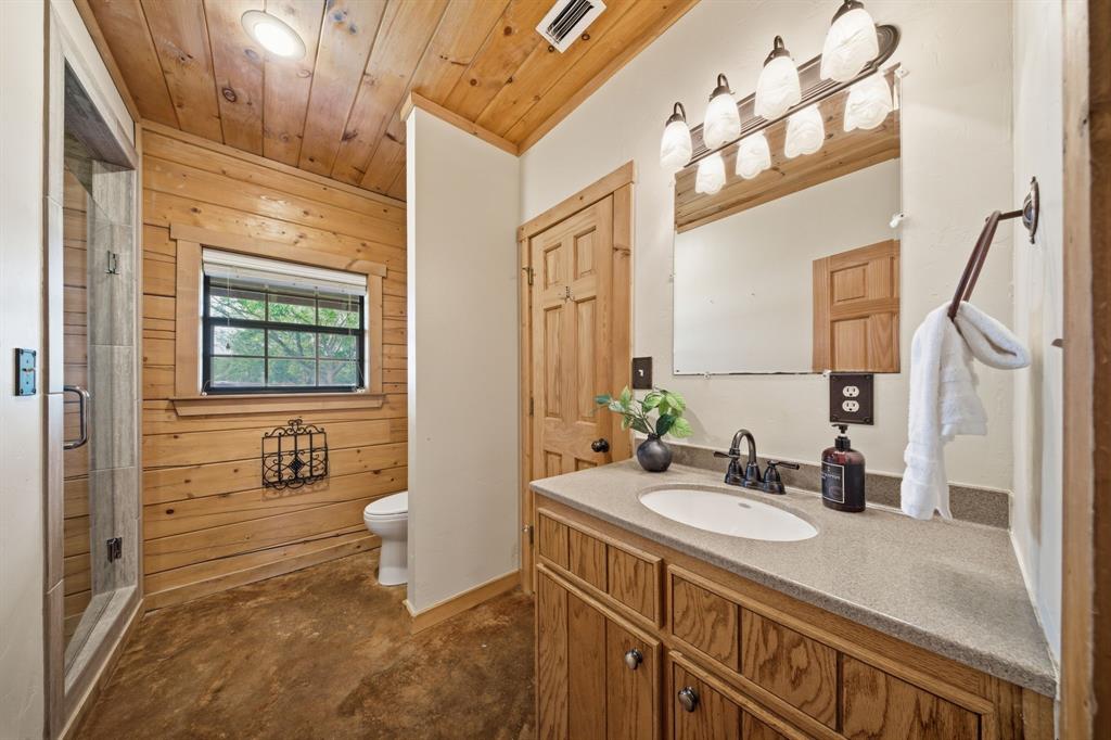465 Emberson Ranch Road Pilot Point, TX 76258 - Photo 20 of 40 a bathroom with a sink a toilet and a mirror
