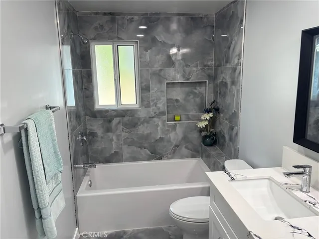 a bathroom with a sink a toilet a bathtub and shower