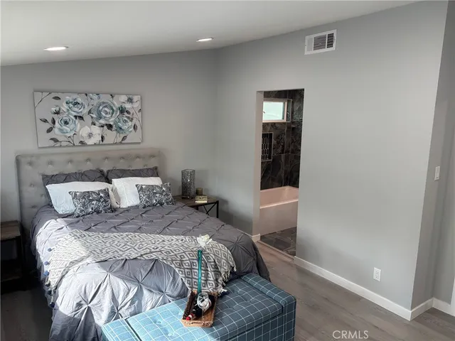 a bedroom with a bed and painting on the wall