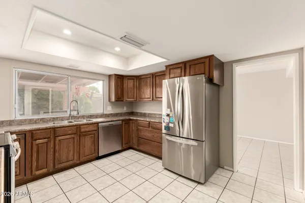a kitchen with stainless steel appliances granite countertop a refrigerator and a sink