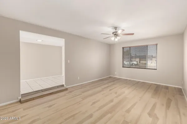 an empty room with fan and windows