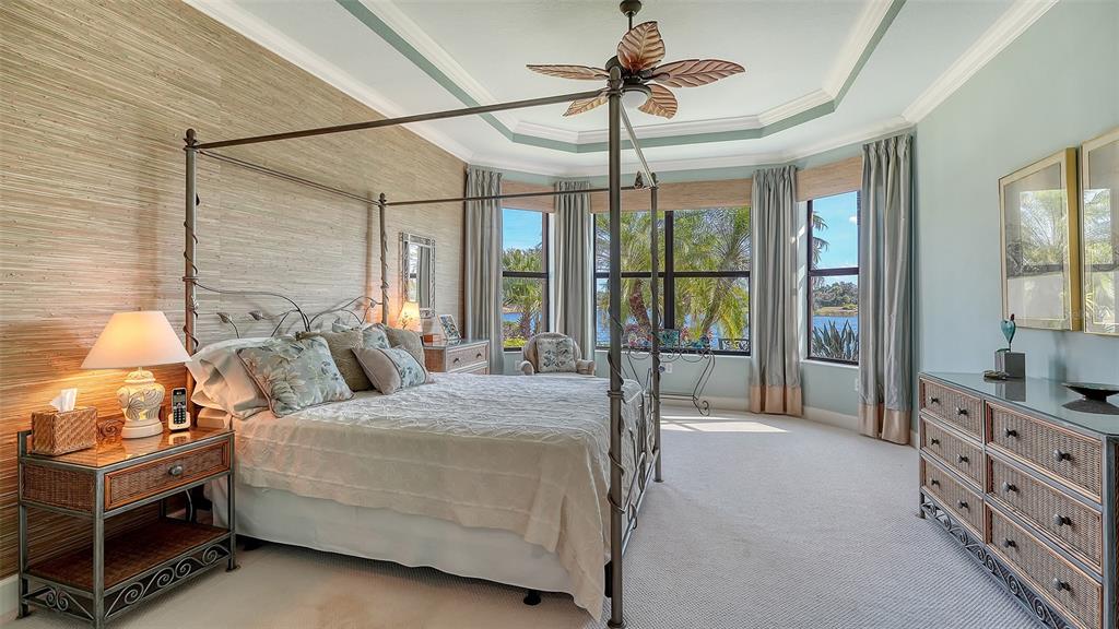 12759 Del Corso Loop Bradenton, FL 34211 - Photo 23 of 74 a bedroom with a bed a chandelier and dresser