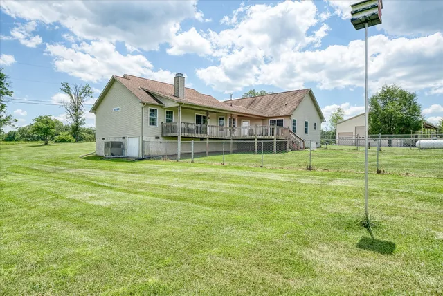 a view of a house with a yard and a large tree