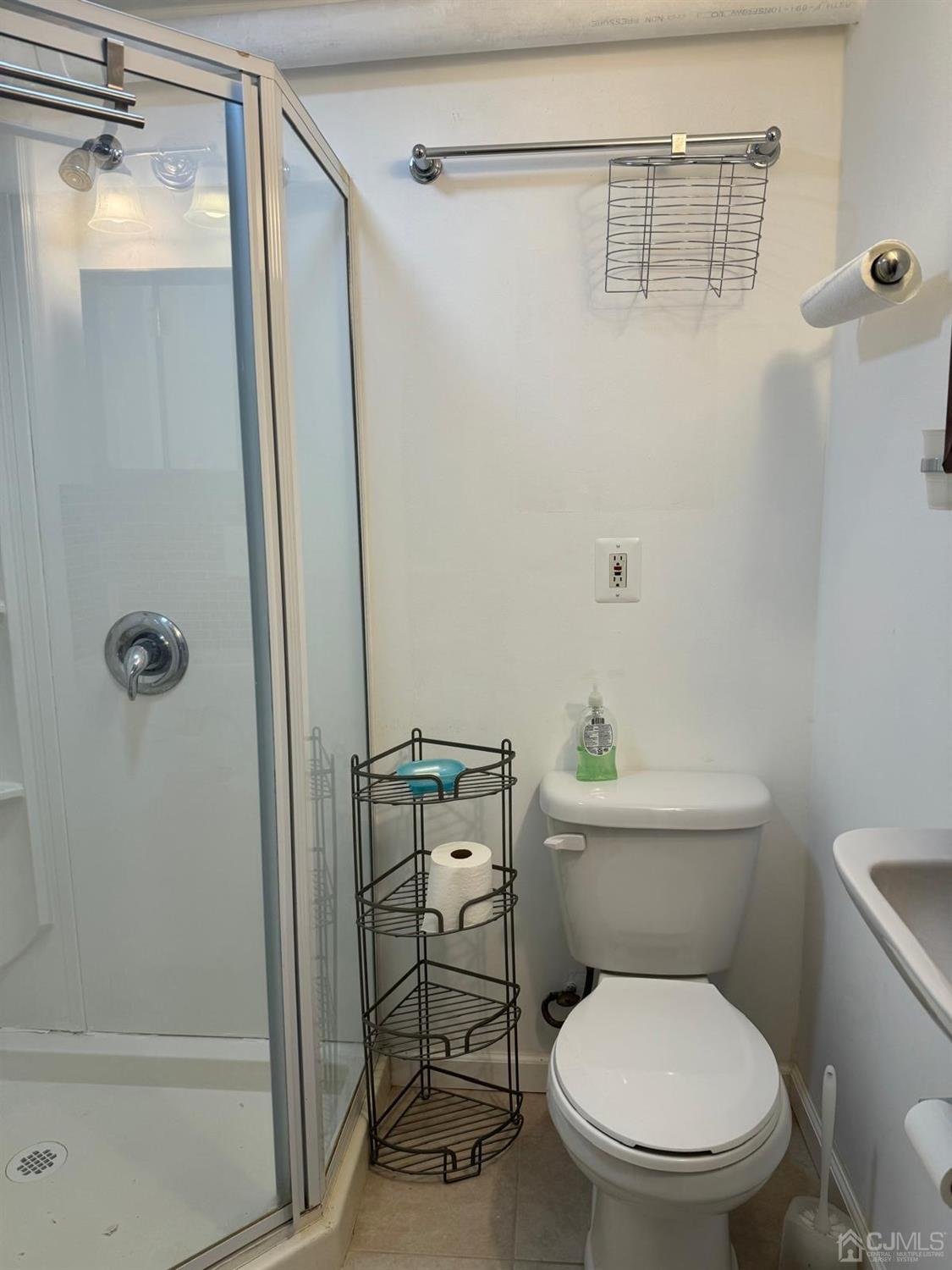 a white toilet sitting next to a shower