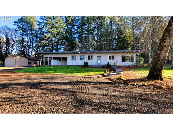 a view of a house with swimming pool and trees in front of it