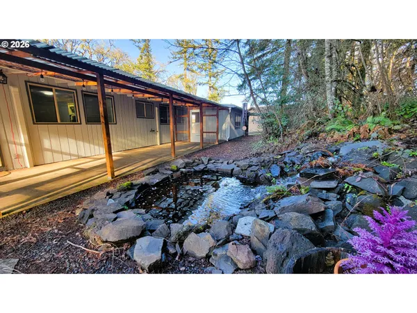 a open area with a street sign and a large tree