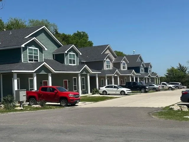 a front view of a house with a garden and parking space