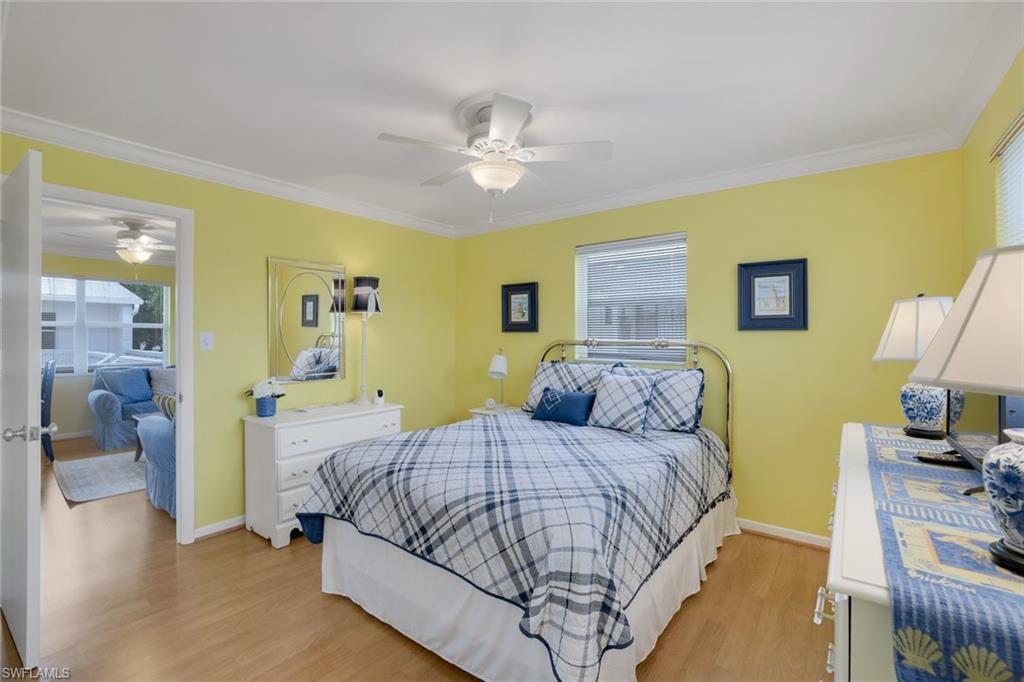 780 10th Avenue South, Unit 22 Naples, FL 34102 - Photo 15 of 17 a bedroom with a bed and a chandelier