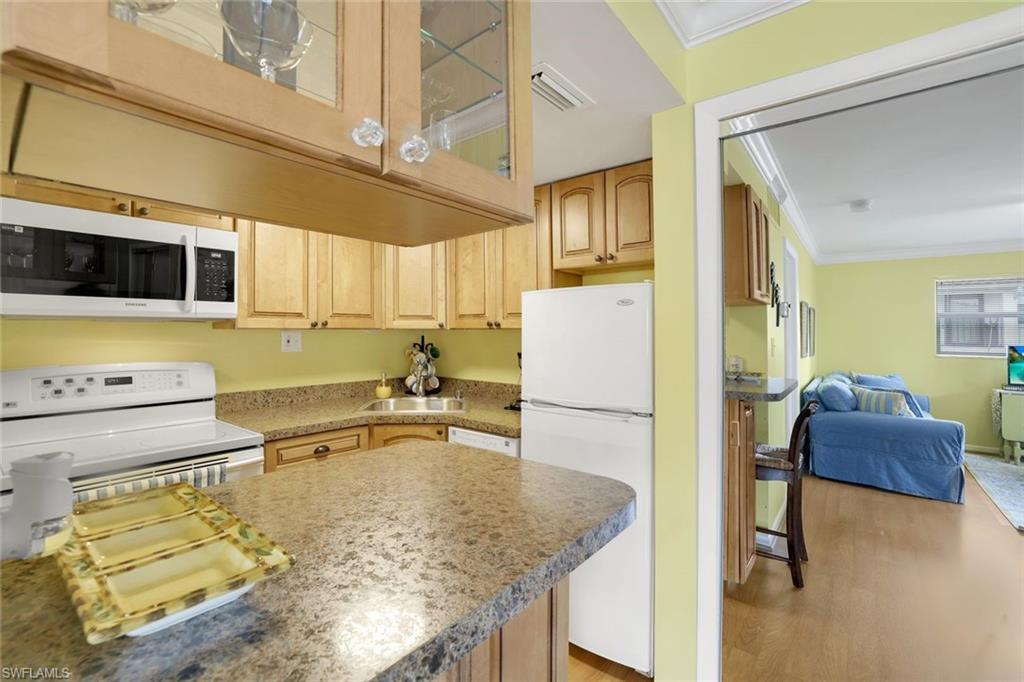 780 10th Avenue South, Unit 22 Naples, FL 34102 - Photo 10 of 17 a kitchen with stainless steel appliances granite countertop a sink and a refrigerator