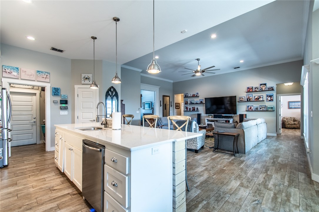 15422 Dyna Street Corpus Christi, TX 78418 - Photo 27 of 40 a large kitchen with kitchen island a stove a sink a refrigerator and a living room view
